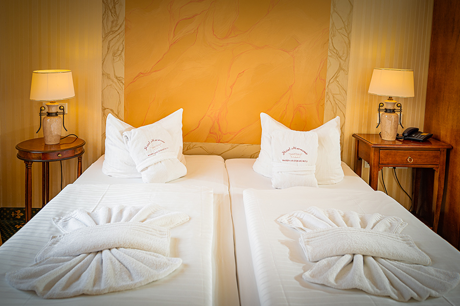 Schönes Doppelbett vor Stilvoller Wand im Hotel Harmonie in Waren an der Müritz